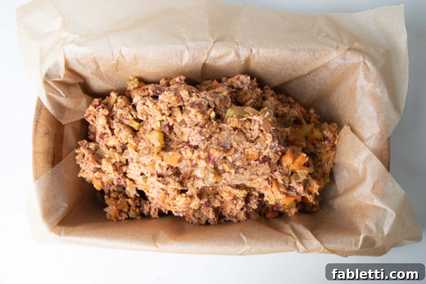 Hearty Plant-Based Meatloaf 12 The mashed bean mixture is neatly spooned into a loaf pan, perfectly lined with parchment paper.