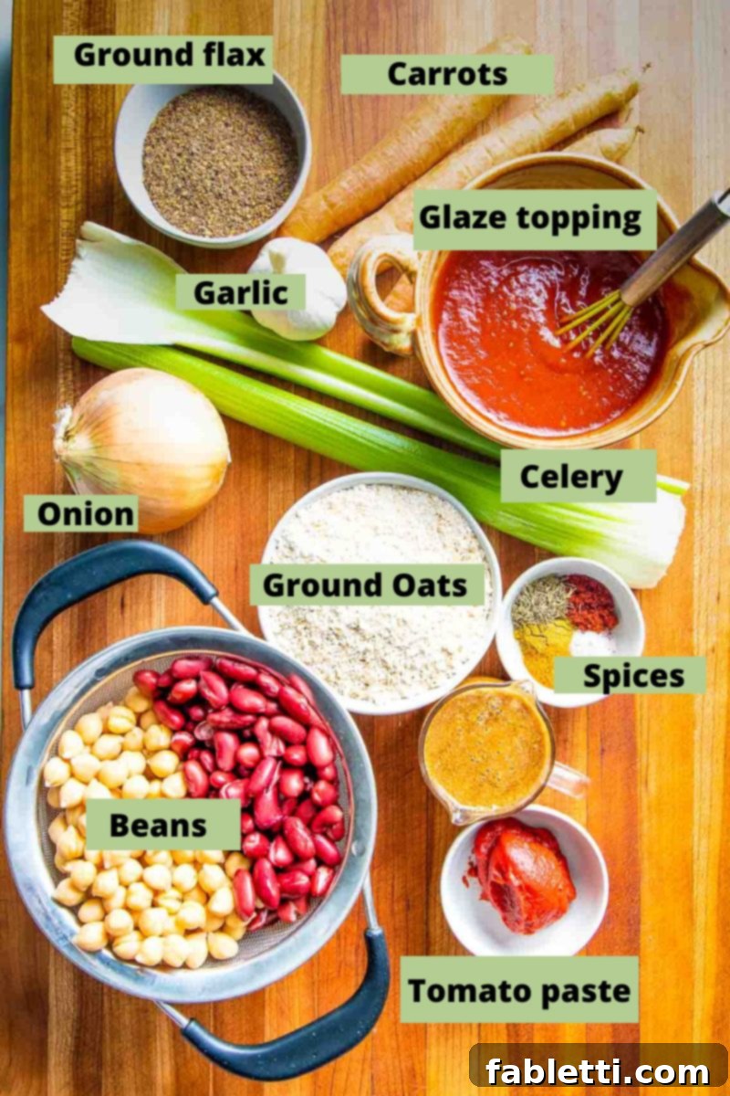 Hearty Plant-Based Meatloaf 3 Labeled ingredients including beans, garlic, ground oats, celery, spices, glaze topping, ground flax, and carrots laid out on a surface.