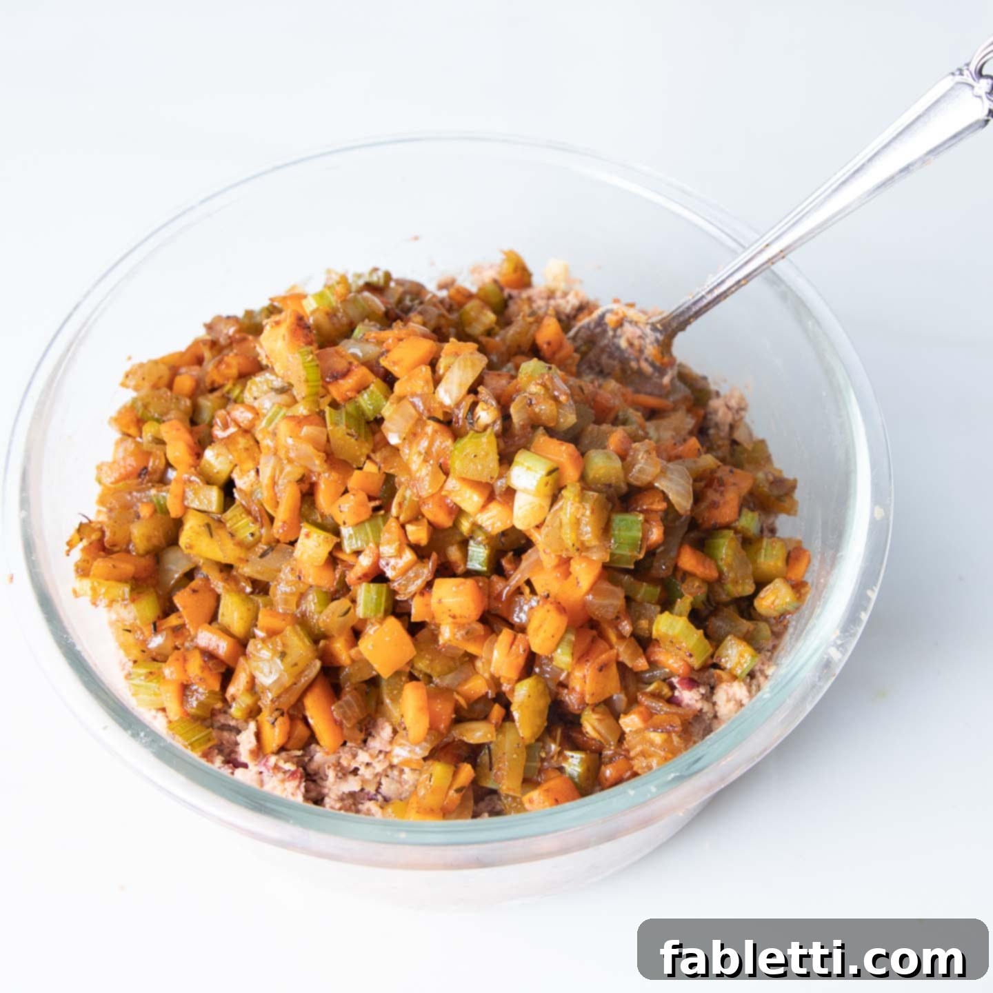 Hearty Plant-Based Meatloaf 10 The mashed bean mixture and sauteed vegetables are combined in a large glass bowl, ready for final mixing.