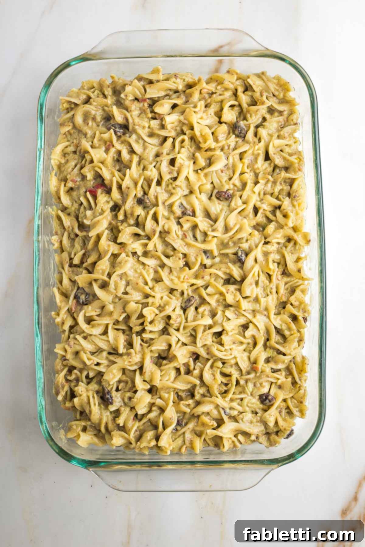 Delicious Dairy-Free Apple Noodle Kugel 12 The unbaked apple noodle kugel mixture is neatly spread into a prepared 9x13-inch baking dish, ready to be placed in the oven or frozen for later enjoyment.