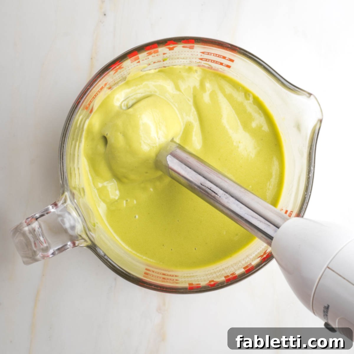 Delicious Dairy-Free Apple Noodle Kugel 5 An immersion blender actively transforms the avocado, egg, oil, and honey mixture into a smooth, light green, and incredibly creamy custard consistency, ready to bind the kugel ingredients.