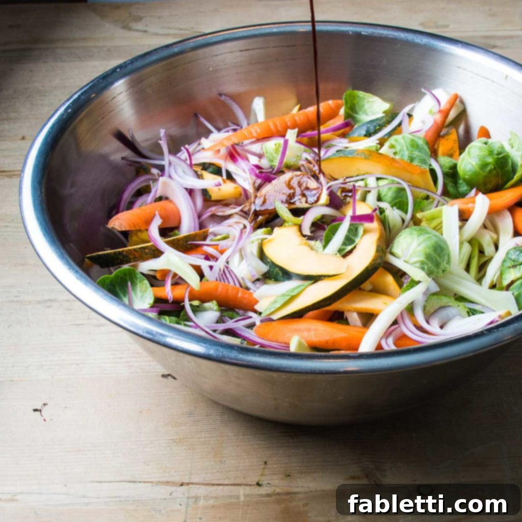 Balsamic Glaze poured over a bowl full of colorful vegetables.