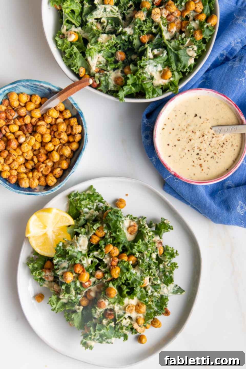 Plate of Vegan Kale Caesar Salad with chickpea croutons, creamy dressing, and a lemon wedge