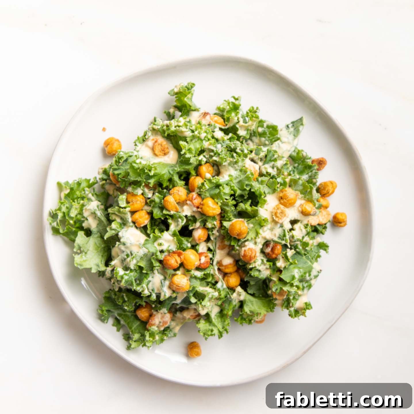 A plate of Vegan Kale Caesar Salad featuring vibrant kale, creamy dressing, and roasted chickpeas