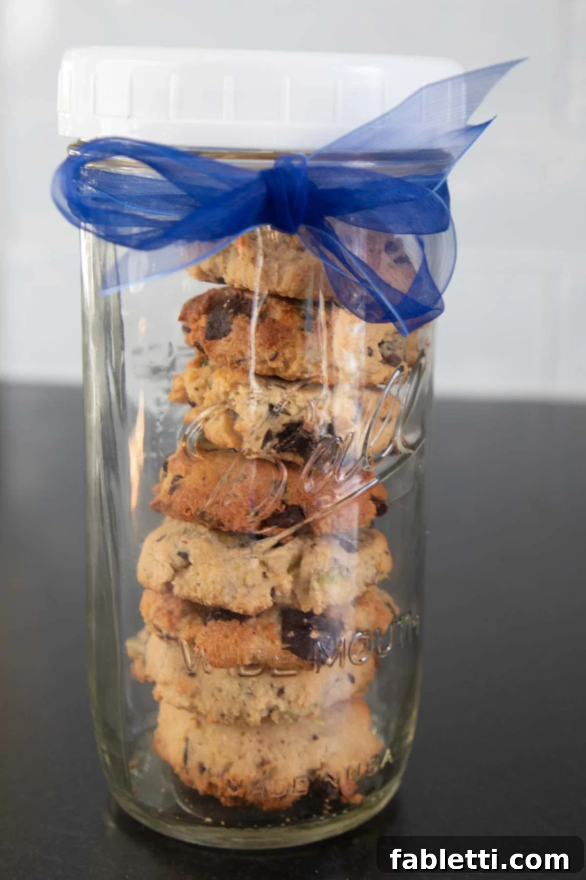 Guilt-Free Chocolate Chunk Bliss 13 Stack of chocolate chunk cookies in a tall jar with blue ribbon.
