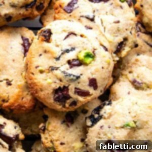 Guilt-Free Chocolate Chunk Bliss 15 Pile of chocolate chunk cookies with pistachios and dried cherries.
