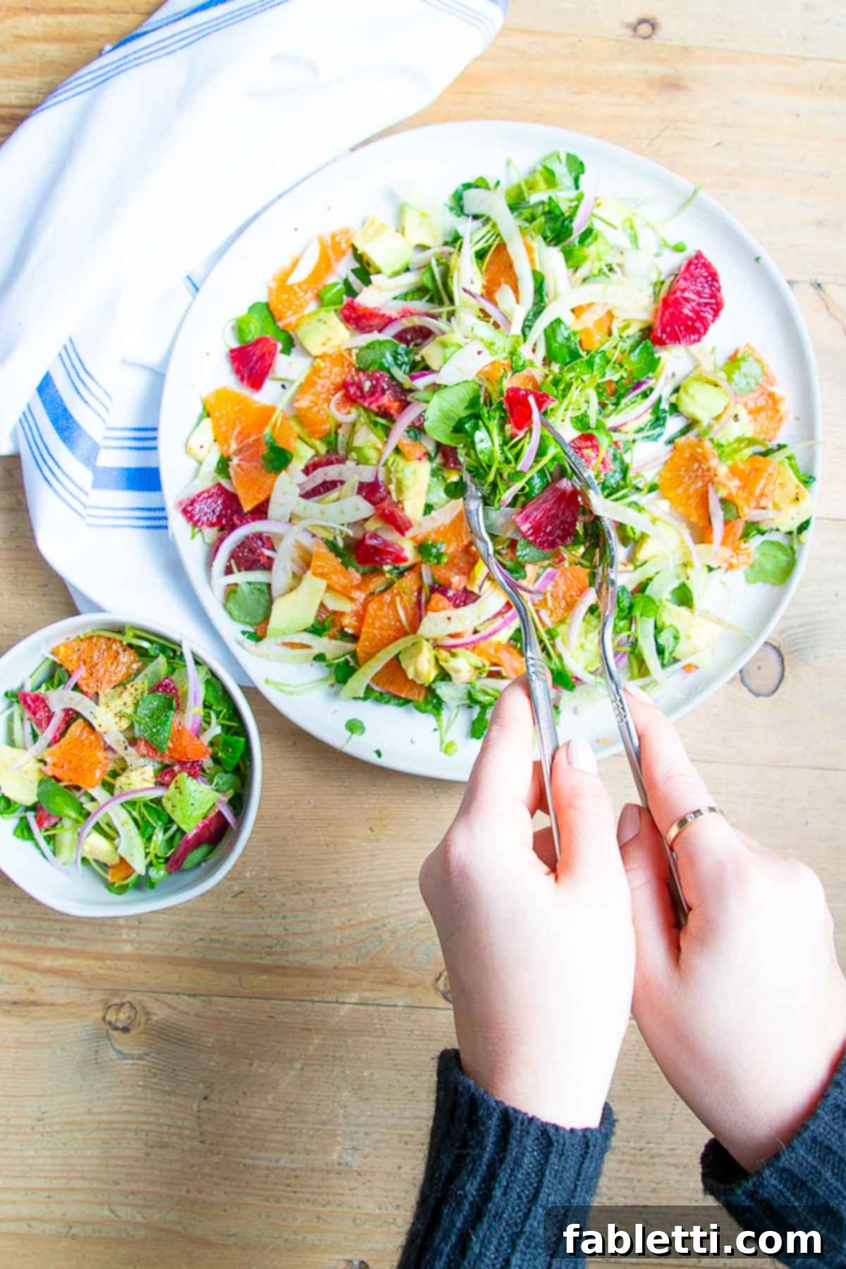 Radiant Orange Fennel 4 Scooping orange, fennel, avocado and onion salad into a small bowl.