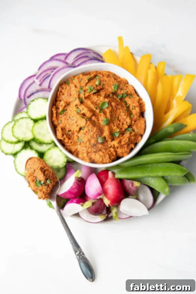 Vibrant Oil-Free Romesco 2 Ruddy Tomato dip with vibrant veggies artfully arranged on a platter, showcasing its rich texture and color.