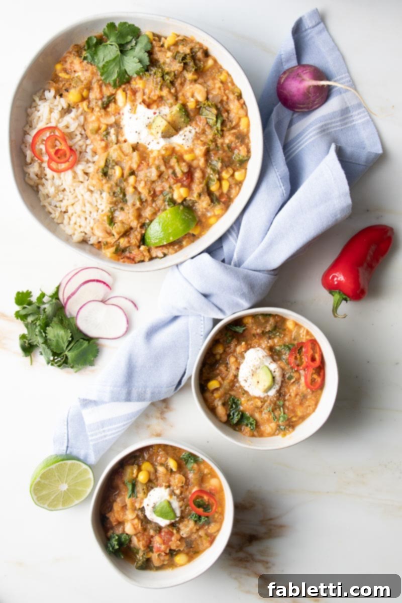 Hearty Vegan White Bean Chili 6 Two cozy bowls of white bean chili beautifully garnished with fresh radishes, colorful peppers, bright lime wedges, and fragrant cilantro.