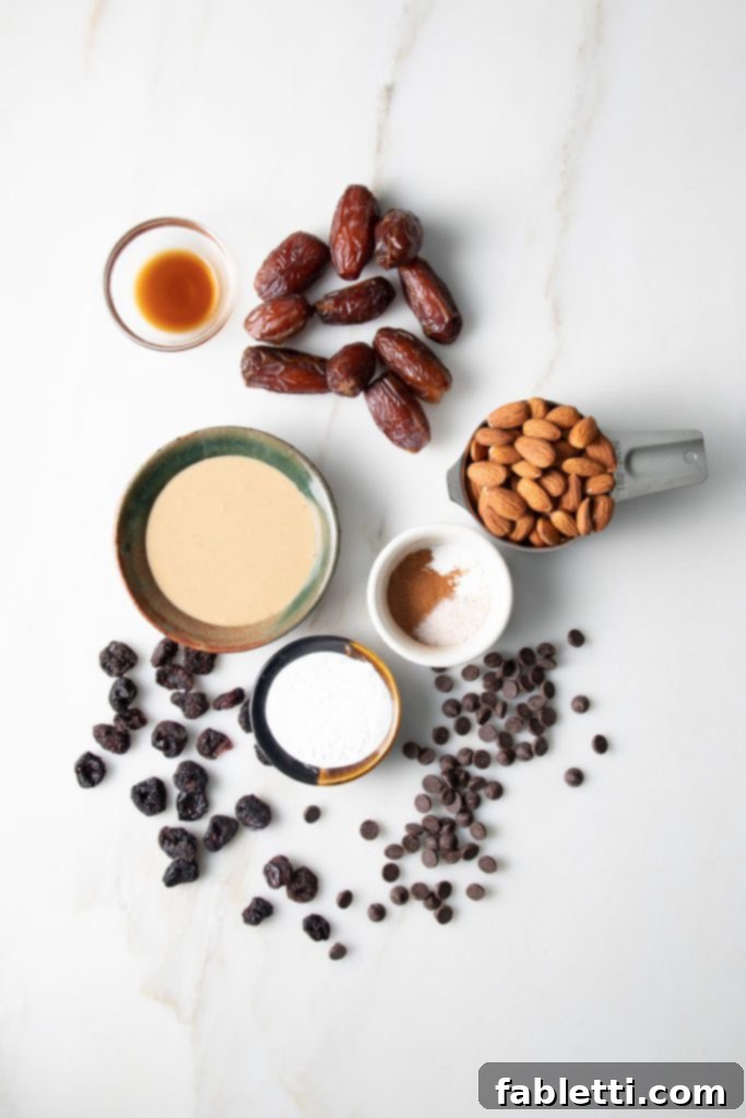 Plant-Based Biscotti Perfection 3 Tahini, Dates, Almonds, arrowroot powder, cinnamon, baking powder, vanilla, chocolate chips and dried cherries artfully arranged.