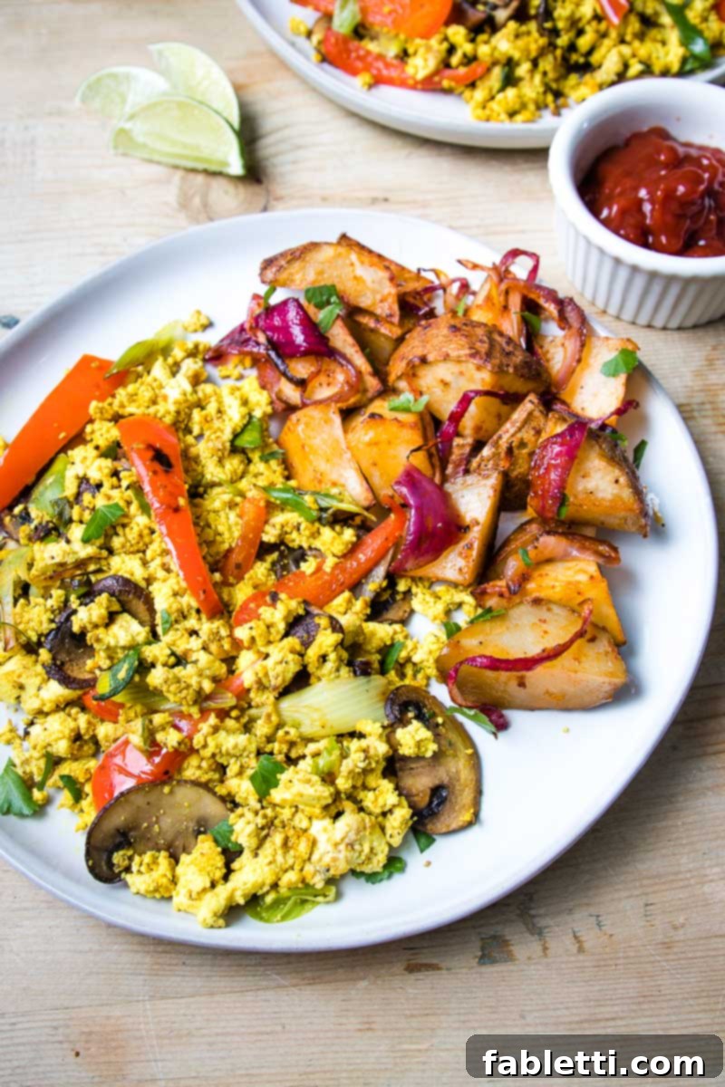 Golden Tofu Scramble 7 Large white plate filled with veggie tofu scramble and a side of breakfast potatoes.