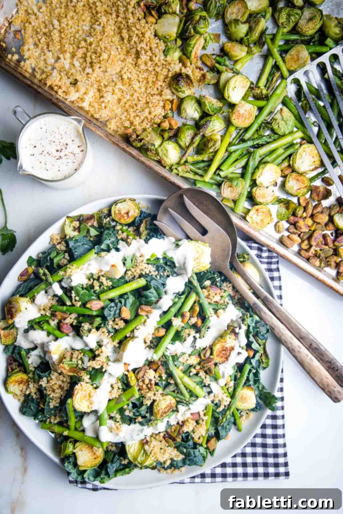 Golden Crisp Quinoa Salad with Silky Plant-Based Dressing 11 A beautifully composed salad with roasted vegetables and grains, served alongside a creamy dressing pitcher and a tray of extra roasted components.
