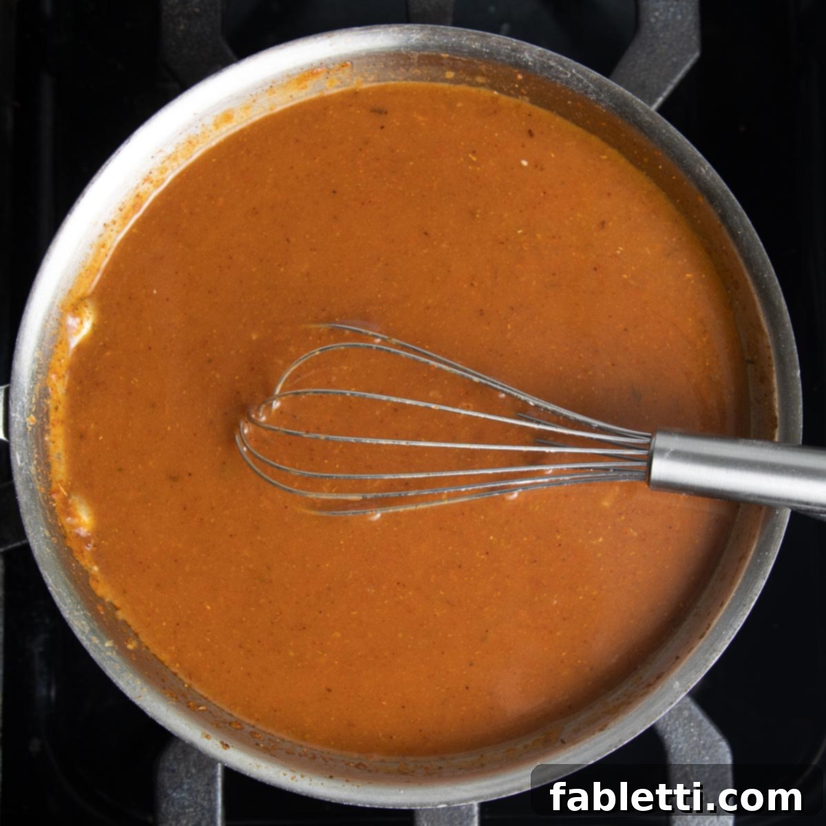 Homemade Red Enchilada Sauce thickening on the stove.