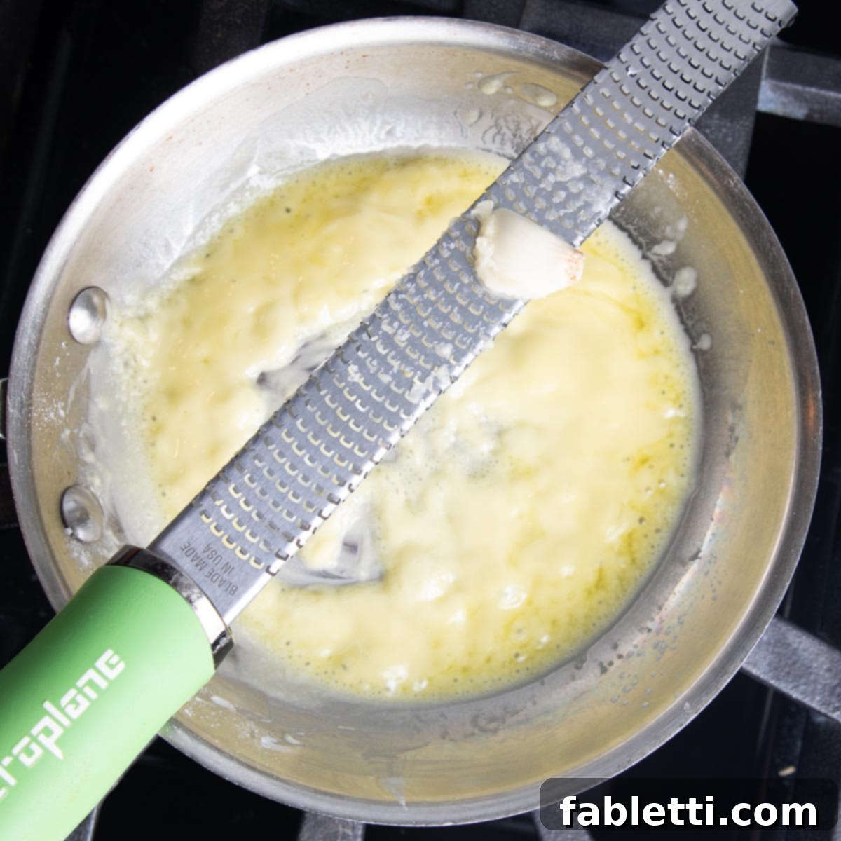Zesting garlic over the pan with the roux.