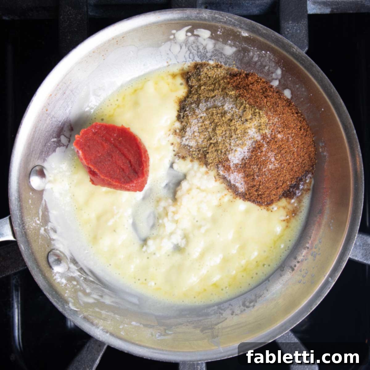 Small pan with roux, tomato paste, garlic and spices