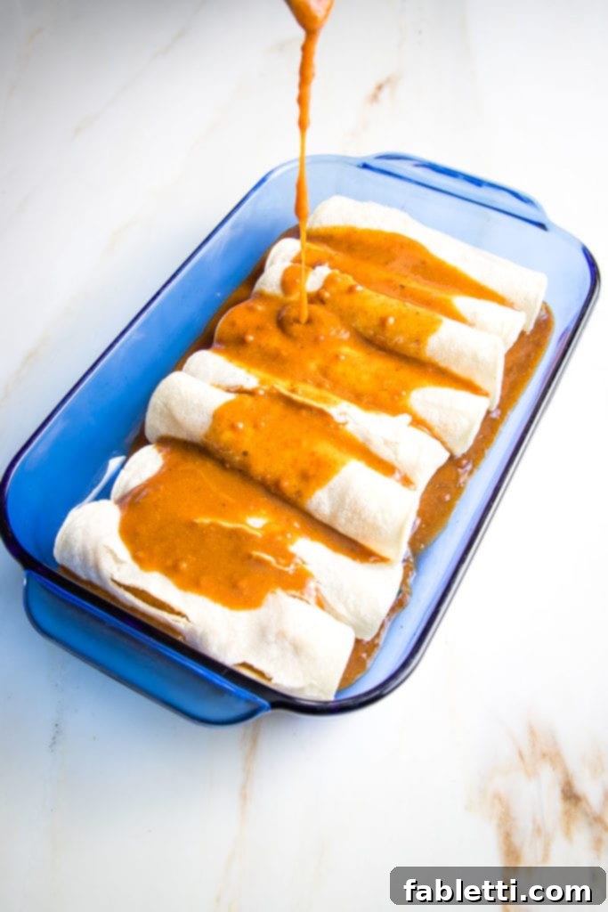 Hearty Plant-Based Enchilada Bake 9 Red enchilada sauce poured on top of veggie filled enchiladas