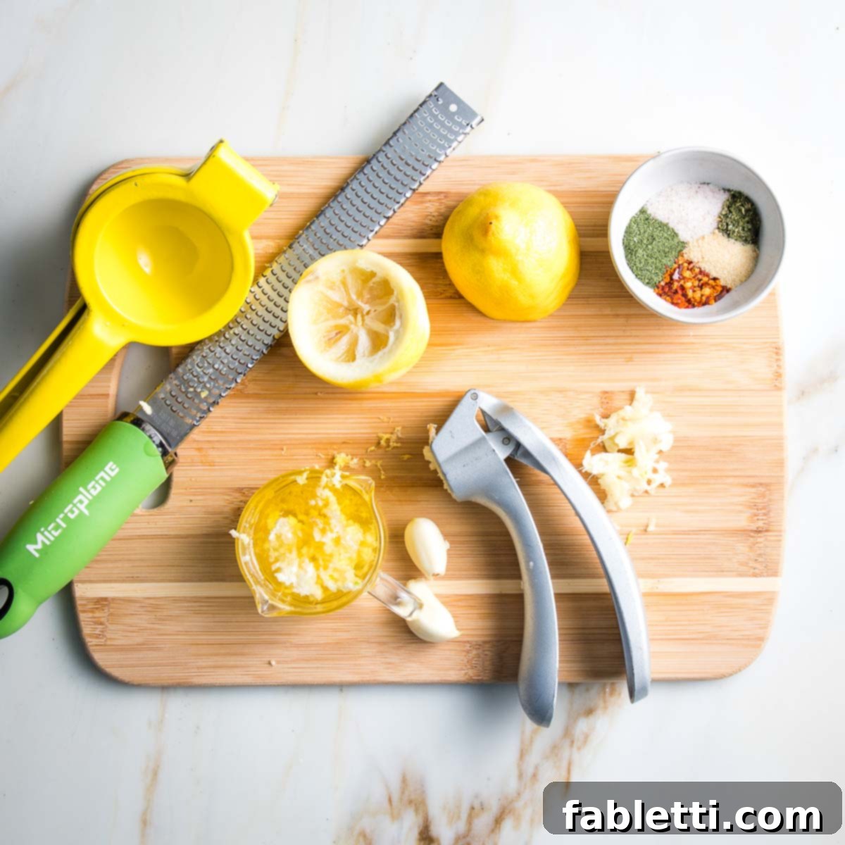 Juicing fresh lemons, pressing cloves of garlic, and mixing a blend of spices for the broccoli marinade.