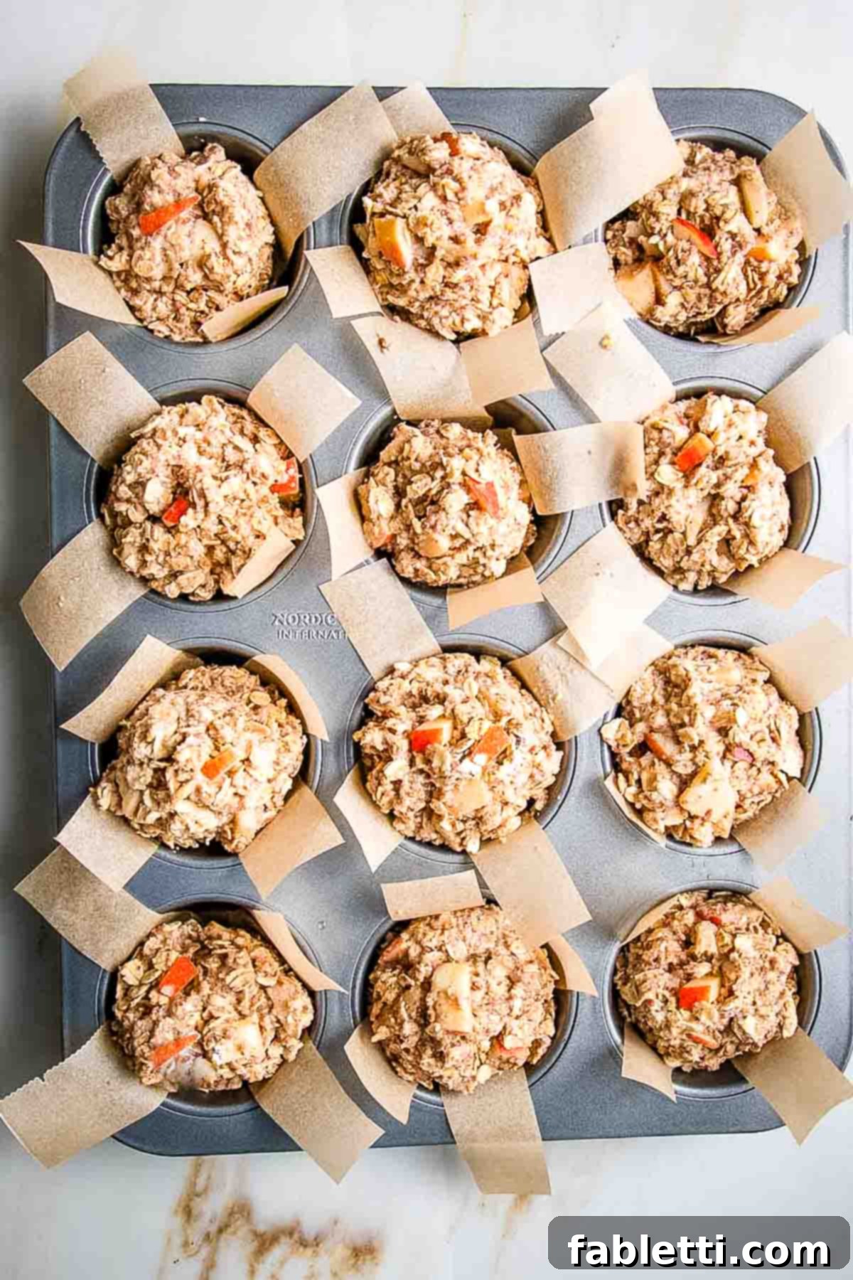 Muffin tin with all compartments filled with batter, ready for baking.