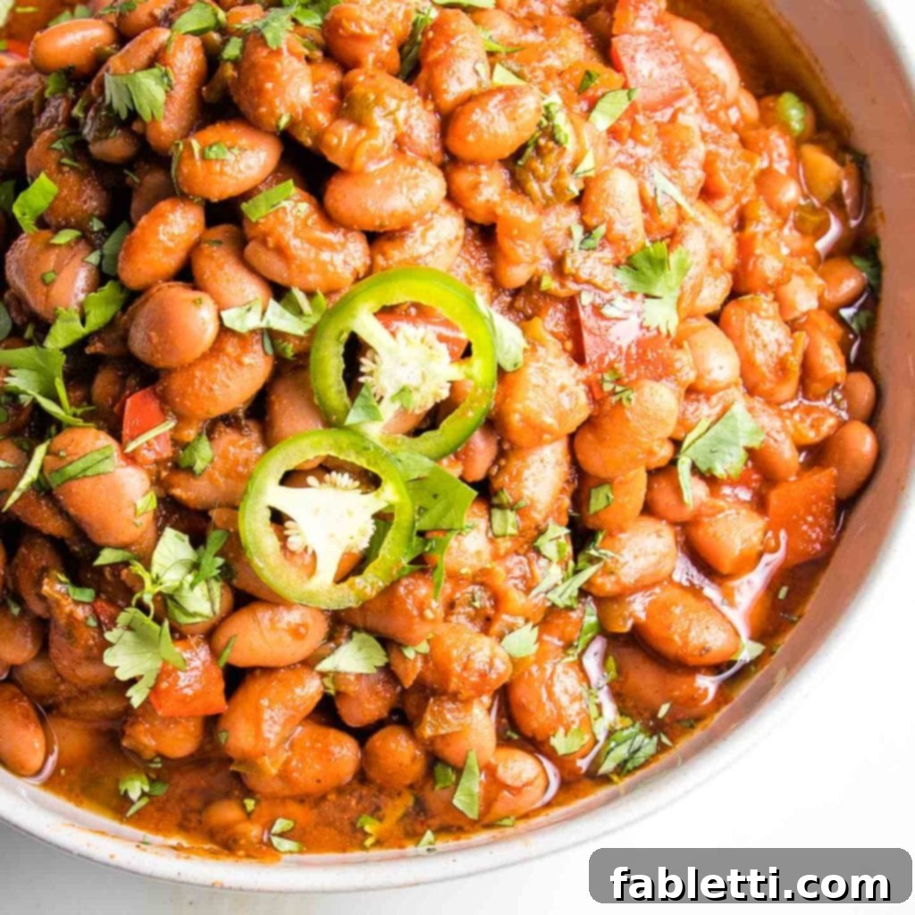 Easy Instant Pot Mexican Pinto Beans 11 Mexian Style pinto beans in tomato sauce, garnished with sliced jalapenos and sprinkled with fresh chopped herbs