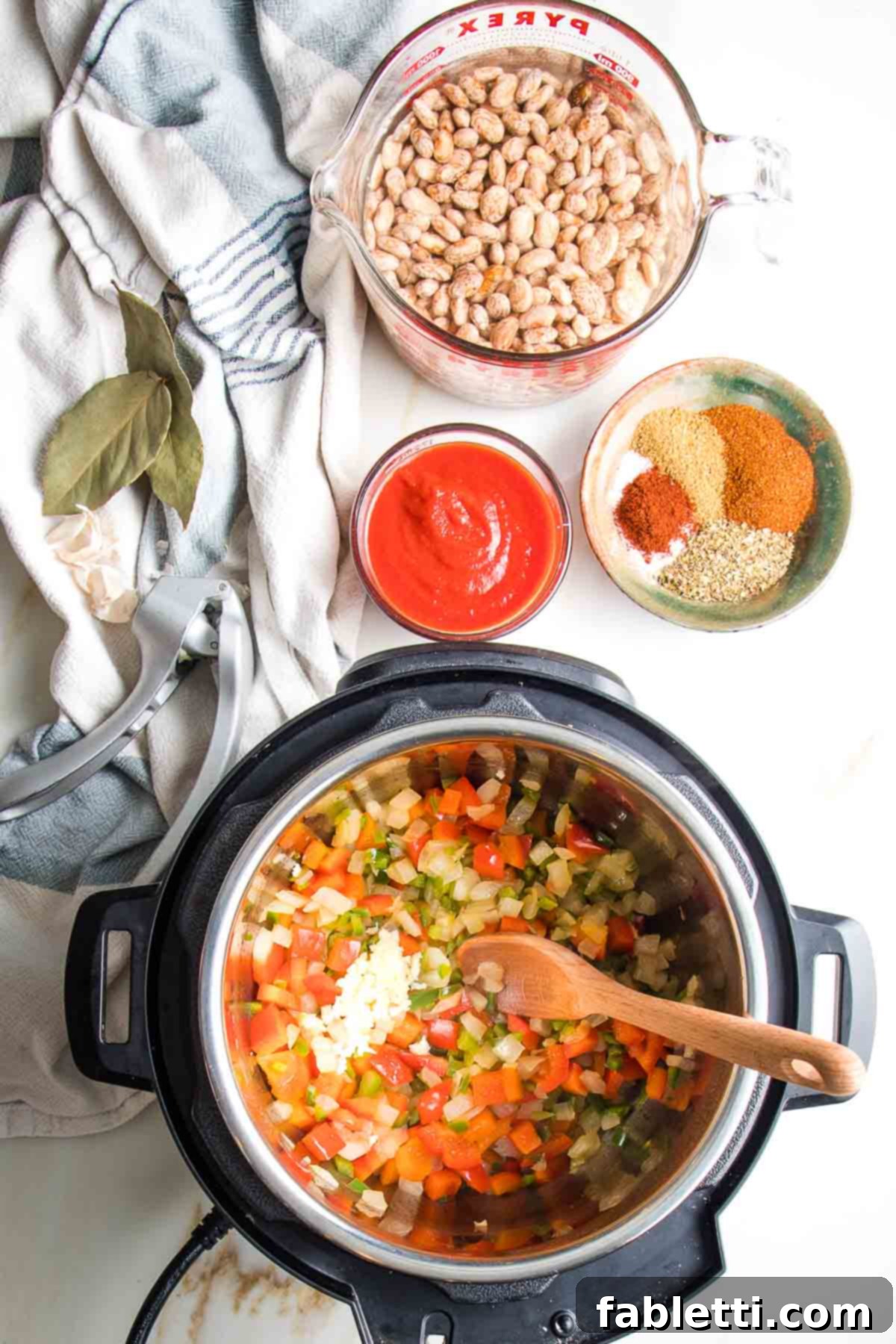 Easy Instant Pot Mexican Pinto Beans 7 Instant pot with sauteed veggies, pressed garlic on top. Also some tomato sauce, spices and soaking pinto beans.