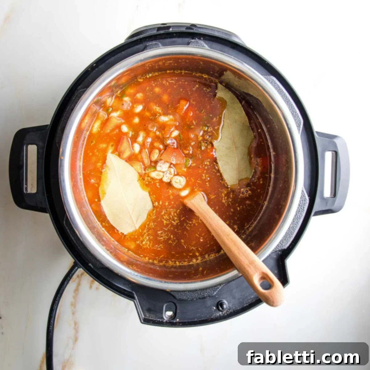 Easy Instant Pot Mexican Pinto Beans 9 Instant pot filled with tomato sauce, spices, bay leaves and veggies.