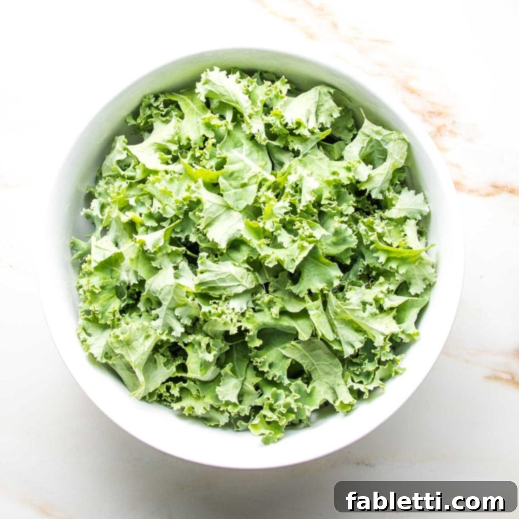 Vibrant Vegan Lentil Medley 6 A large white bowl filled with curly green kale.