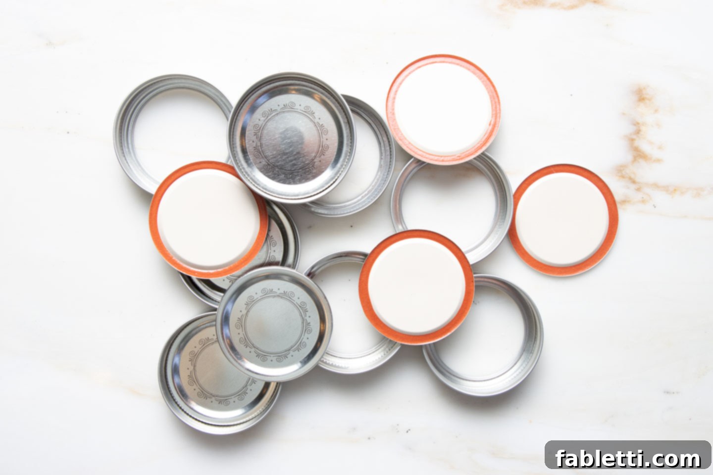 Homemade Blueberry Tart Perfection 7 An organized assortment of canning jar lids and their corresponding rings, demonstrating a simple household item that can be repurposed for baking.