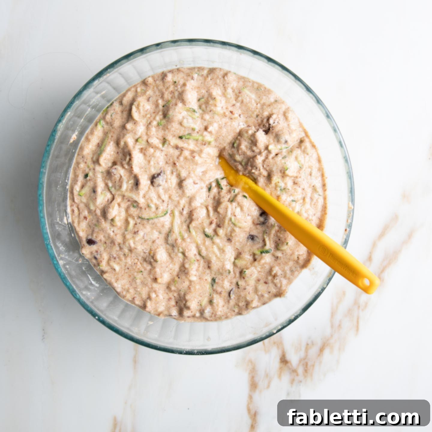 Wholesome Vegan Zucchini Bread Sweetened with Applesauce 7 Close-up of the perfectly combined healthy zucchini bread batter in a mixing bowl, showcasing its rich texture before baking.