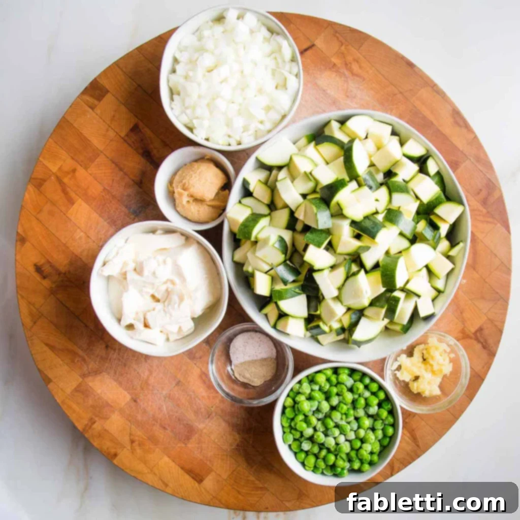 Velvety Zucchini Soup 5 Prepped ingredients like chopped zucchini, peas, garlic, chopped onions, miso paste for creamy zucchini soup.