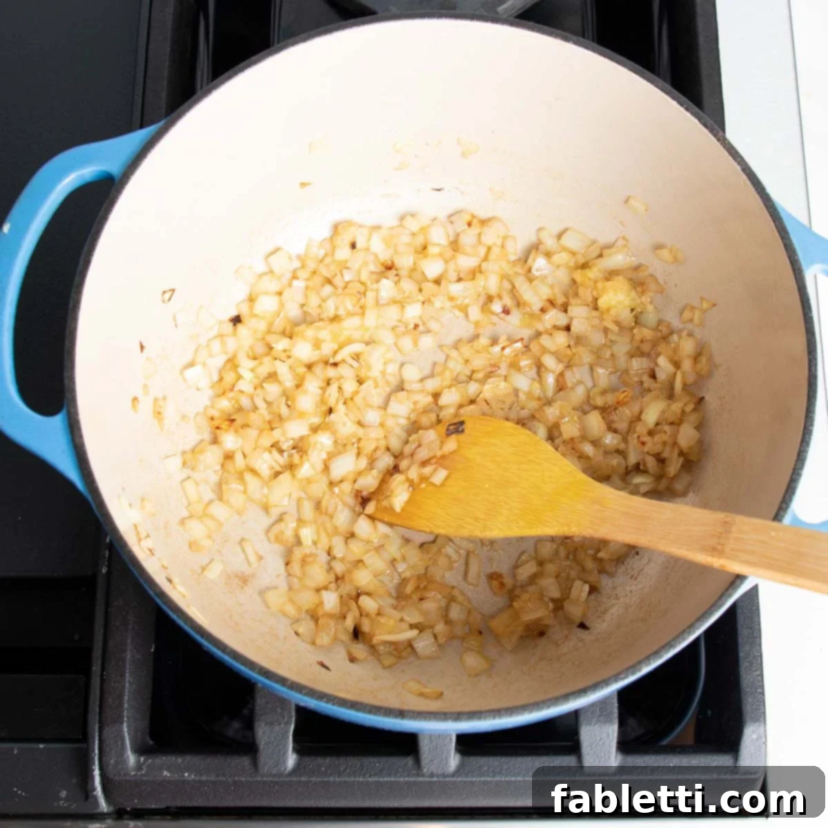 Velvety Zucchini Soup 6 Onions and garlic cooking in a dutch oven.