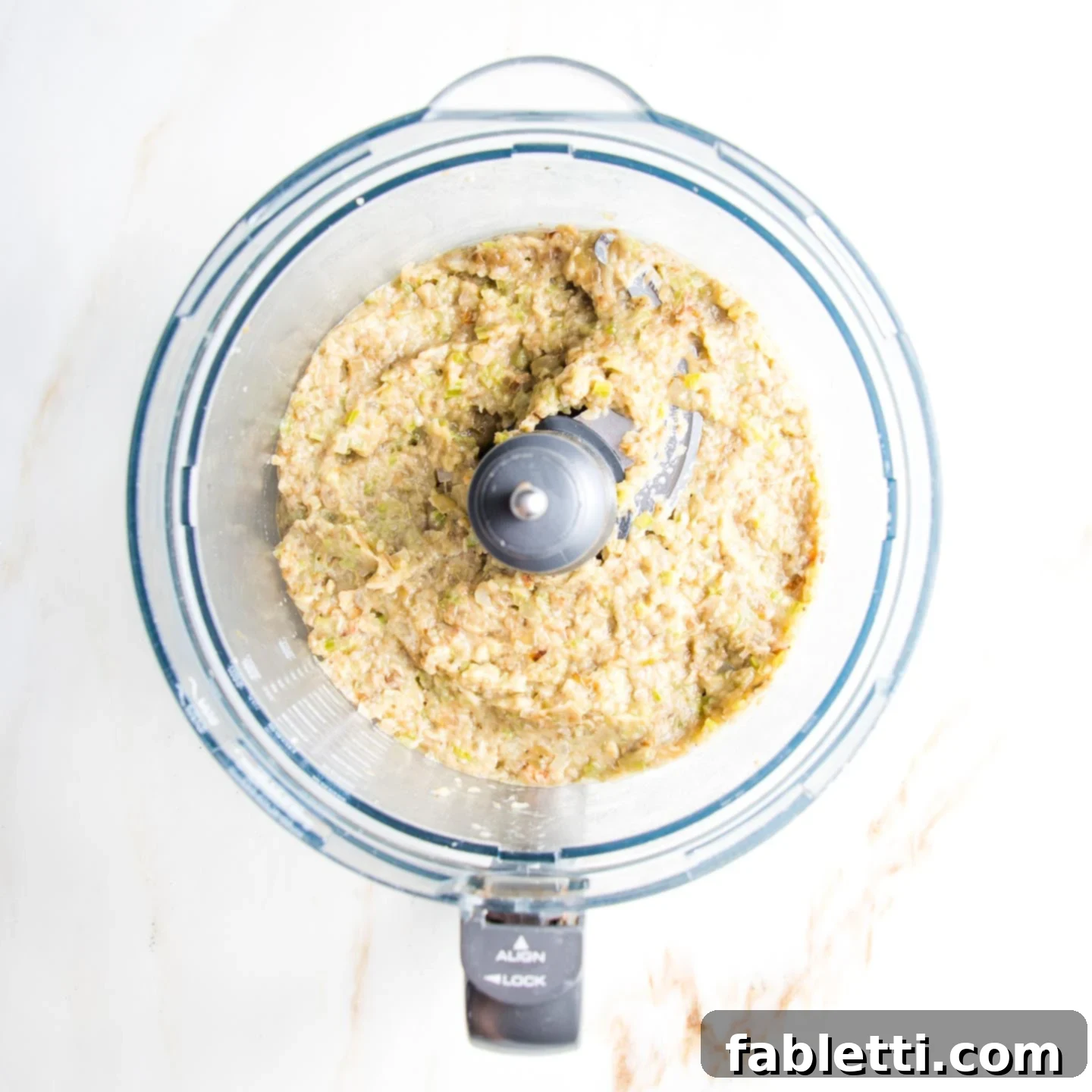 Velvety Roasted Garlic and Tahini Baba Ganoush 9 Chunky eggplant dip in the bowl of a food processor.