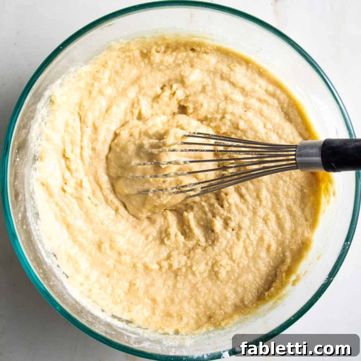 Whisking together all cobbler topping ingredients in a glass bowl until just combined.