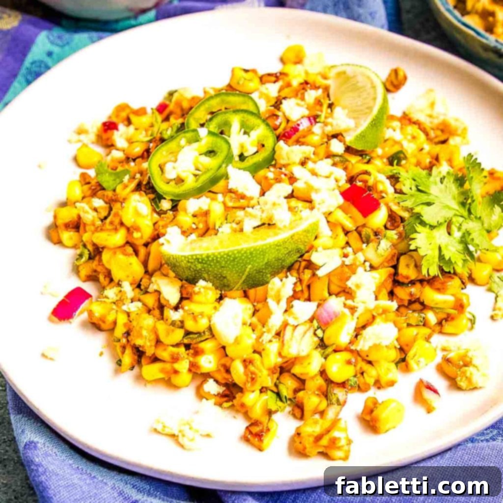 Zesty Vegan Elote 3 Corn salad with pops of color, lime wedges, jalapeno slices and fresh herbs.