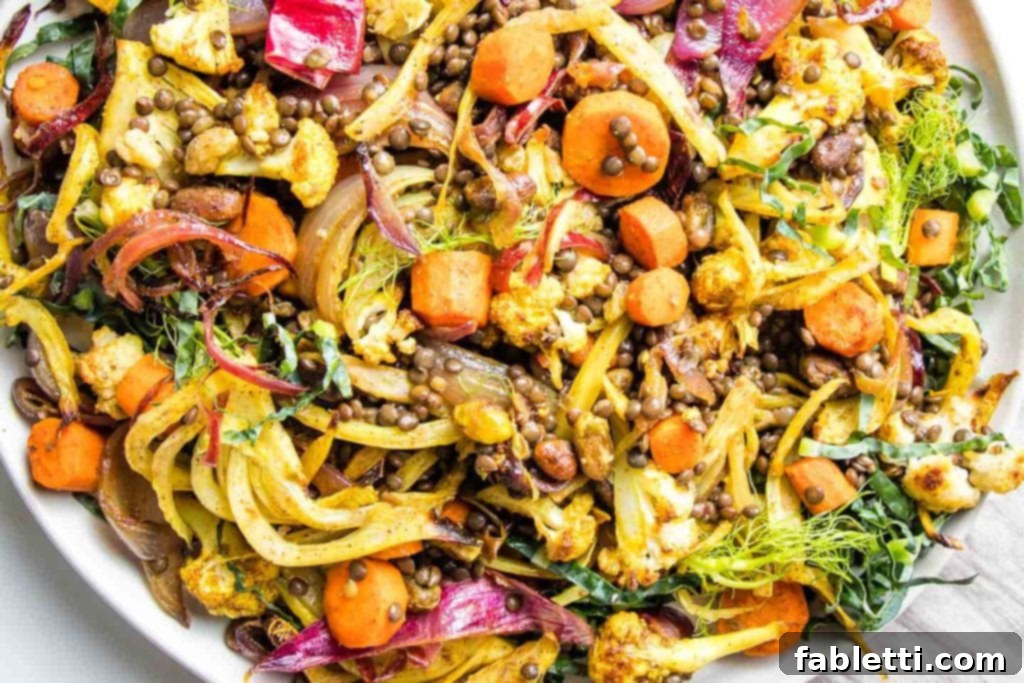 Flavorful Roasted Lentil and Vegetable Medley 3 Bright, colorful roasted red onions, carrots, fennel and cauliflower mixed with lentils, pistachios and raisins in a large white bowl.