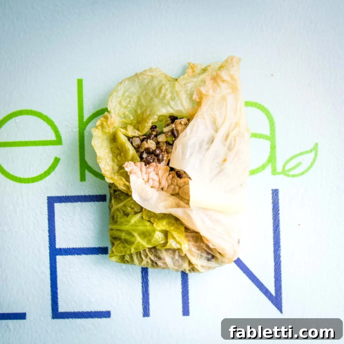 Cabbage leaf, with filling in center, bottom and one side folded into center.