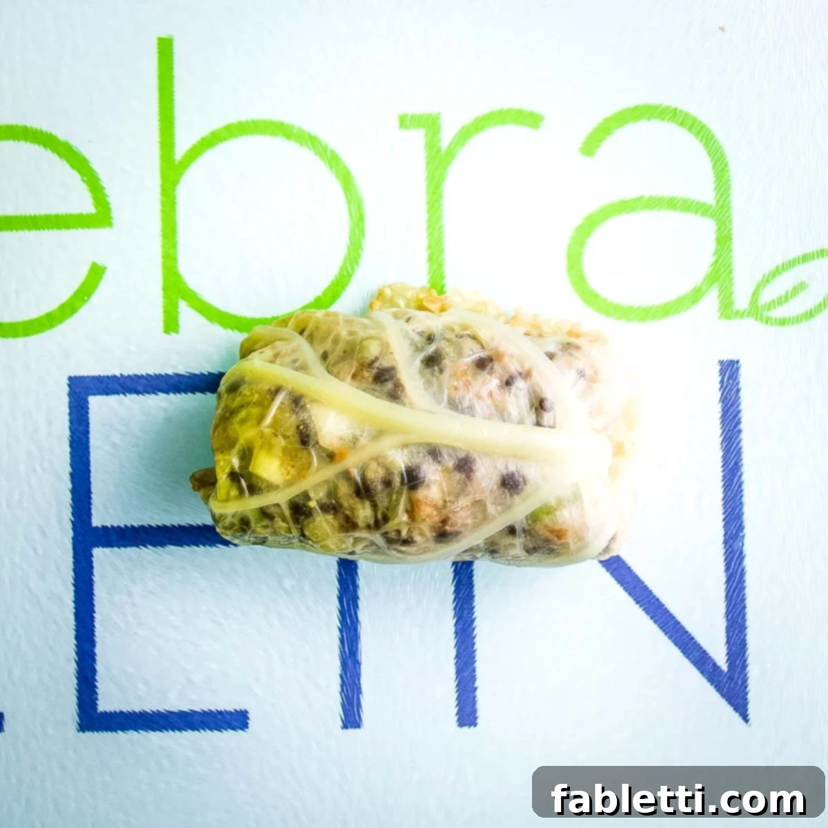 The fully rolled vegan stuffed cabbage, with the seam facing down.