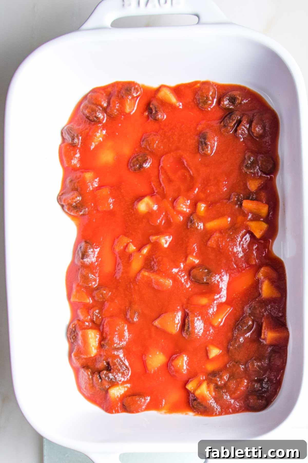 Sweet and sour sauce spread onto the bottom of a baking dish.