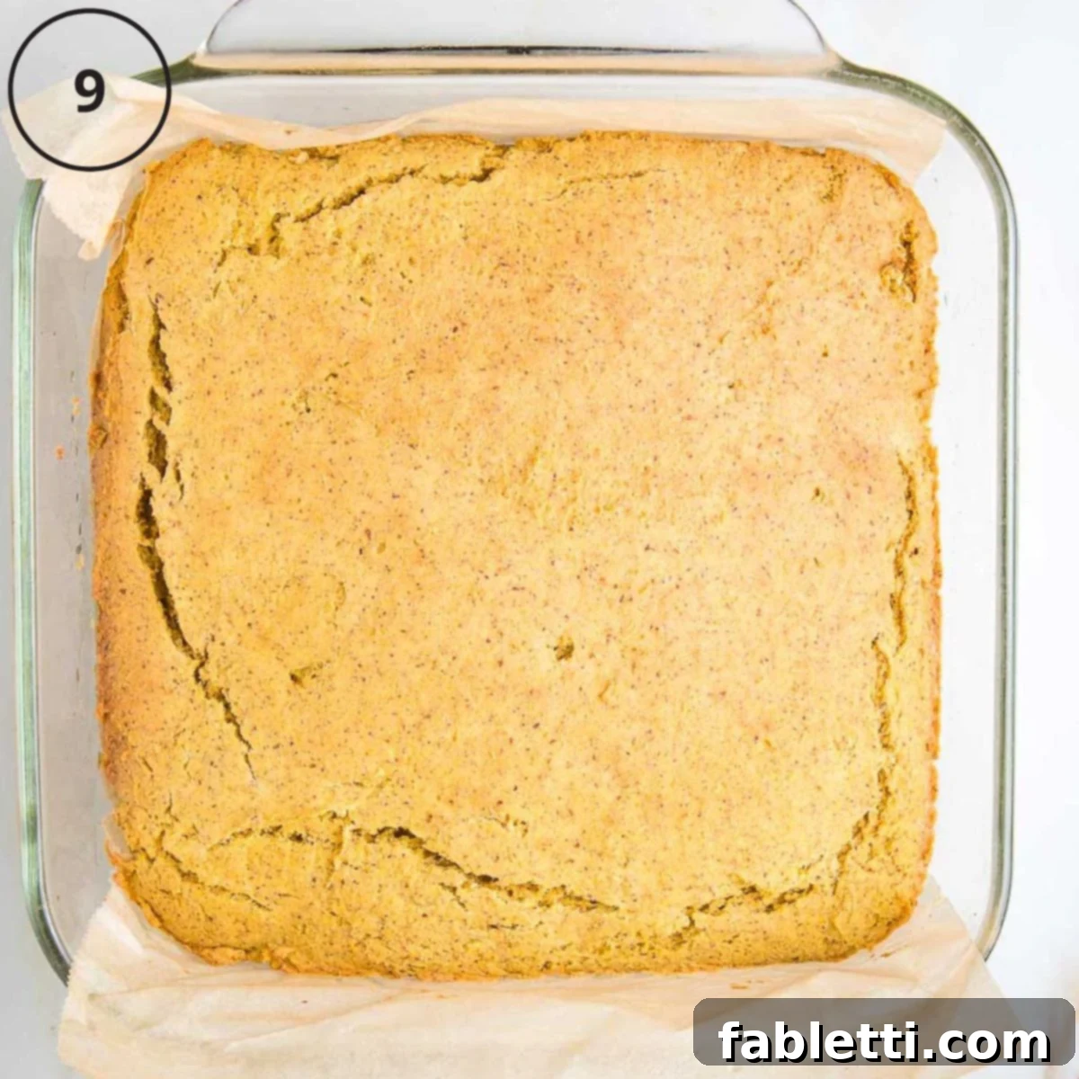 Double Corn Gluten-Free Vegan Cornbread 12 A square baking pan holds a perfectly baked golden-brown cornbread, featuring a cracked top, fresh out of the oven.
