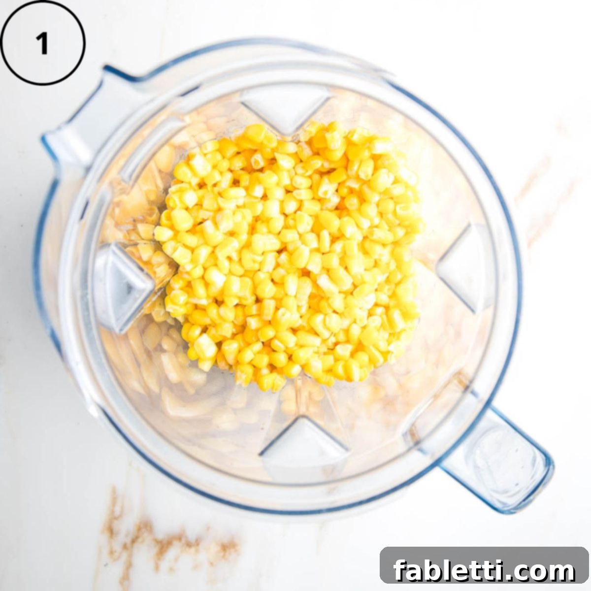 Double Corn Gluten-Free Vegan Cornbread 4 Defrosted frozen corn kernels are placed inside the pitcher of a high-speed blender, ready for blending.