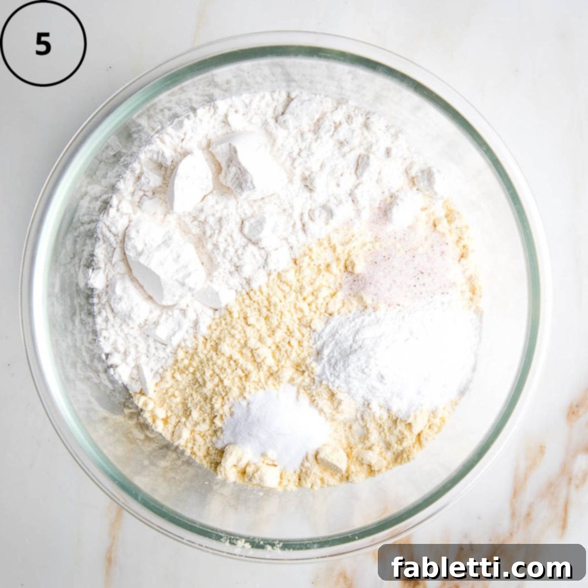 Double Corn Gluten-Free Vegan Cornbread 8 A large mixing bowl contains the dry ingredients for the cornbread: flour, cornmeal, salt, baking soda, and baking powder, perfectly combined.