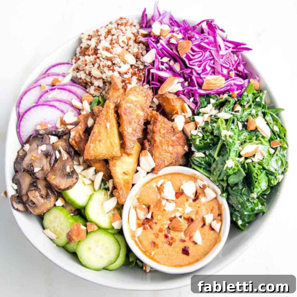 Ultimate Crispy Baked Tofu 2 Crispy tofu in a bowl with red cabbage, sauteed greens, mushrooms, raw veggies and an almond butter sauce.