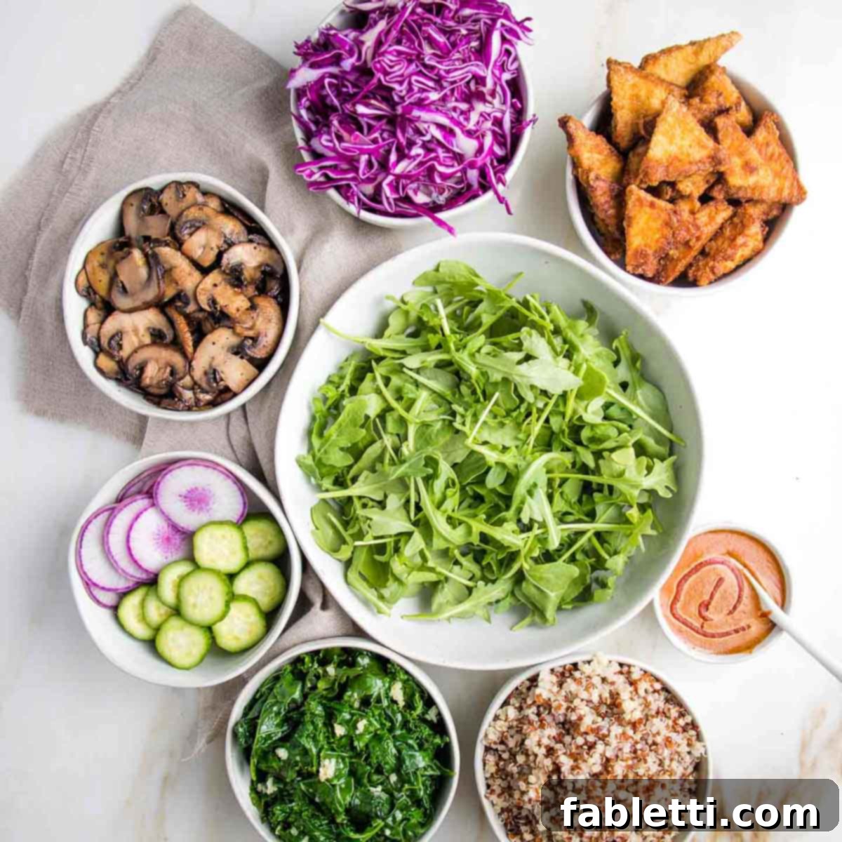Ultimate Crispy Baked Tofu 15 Bowl of greens in center surrounded by bowls of cooked and raw veggies plus crispy tofu.