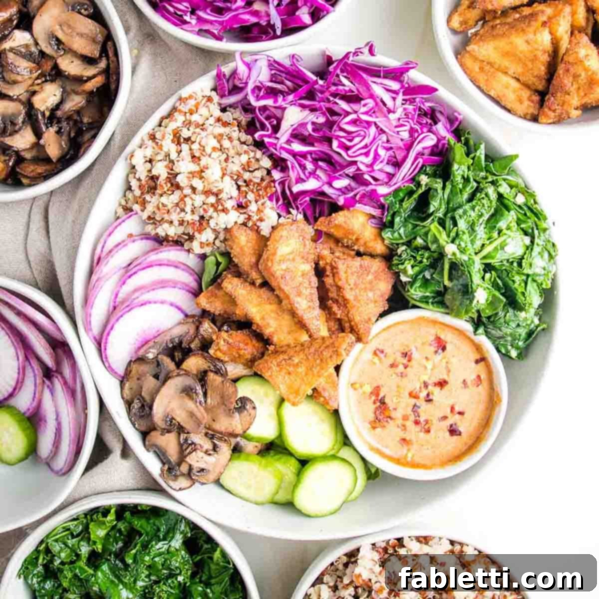 Ultimate Crispy Baked Tofu 16 Colorful bowl of cooked and raw veggies plus crispy tofu and an almond butter sauce.