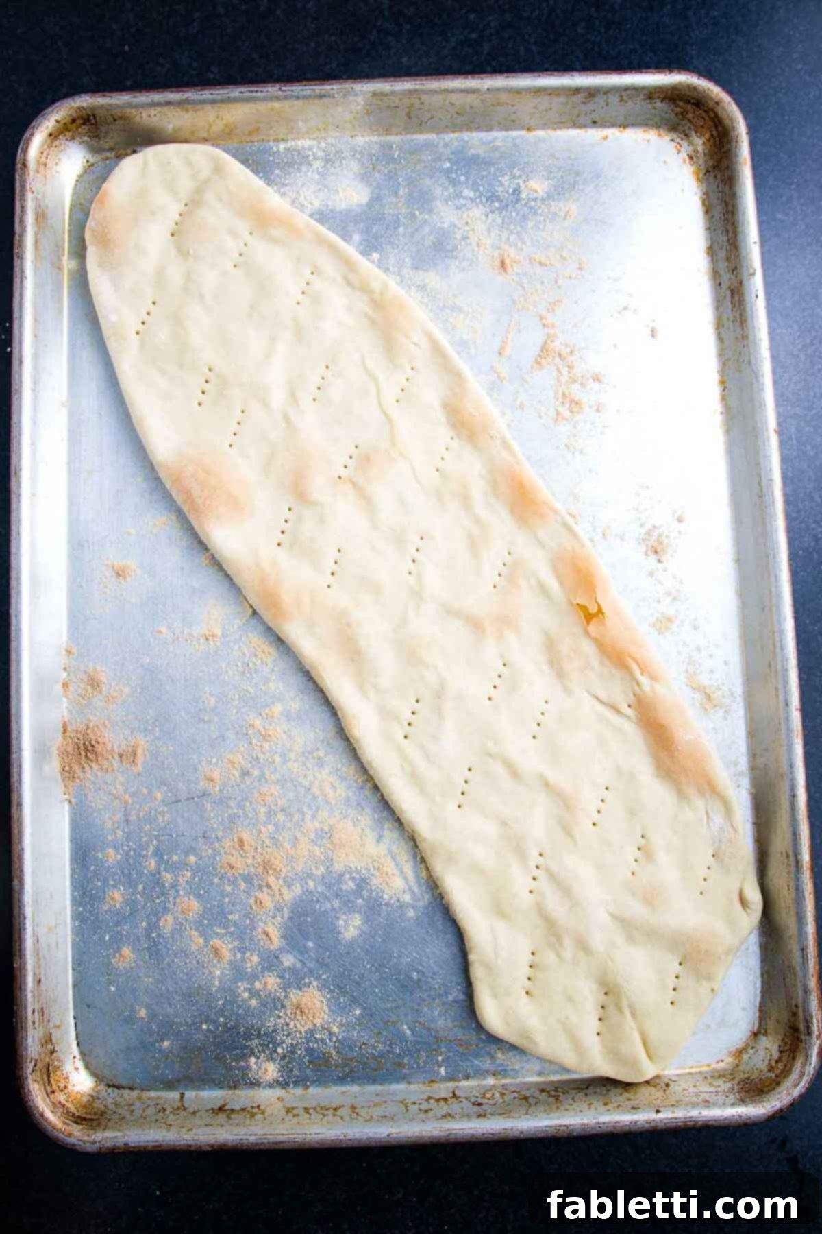 Effortless Plant-Based Flatbread 11 Crisped flatbread pizza dough on a baking sheet.