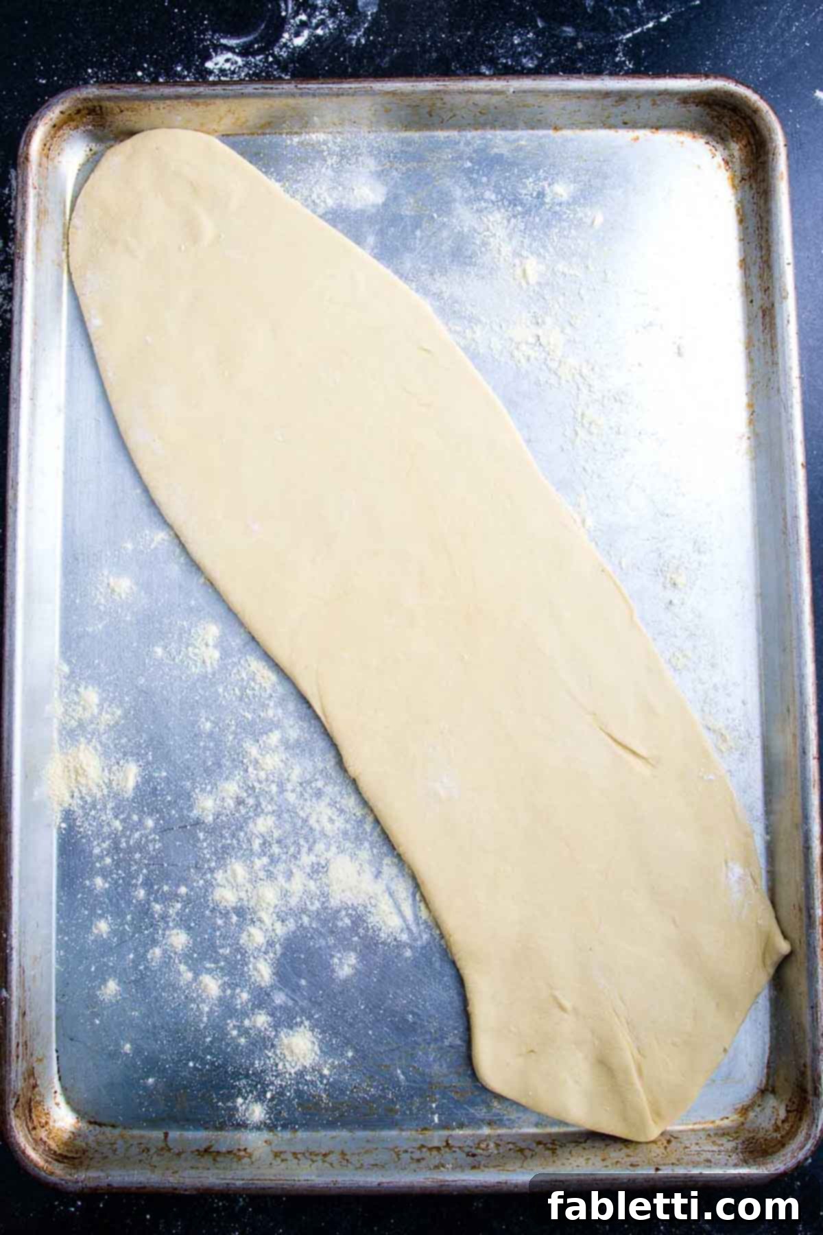 Effortless Plant-Based Flatbread 9 Thinly rolled out oval of pizza dough on a rimmed baking tray.