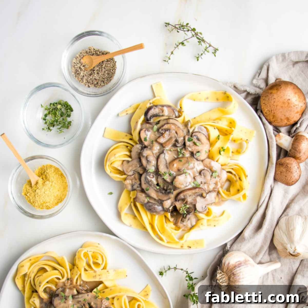 Hearty Vegan Mushroom Stroganoff 15 A generous serving of creamy vegan mushroom stroganoff nestled atop a bed of wide ribbon noodles, garnished with fresh herbs and a sprinkle of black pepper.