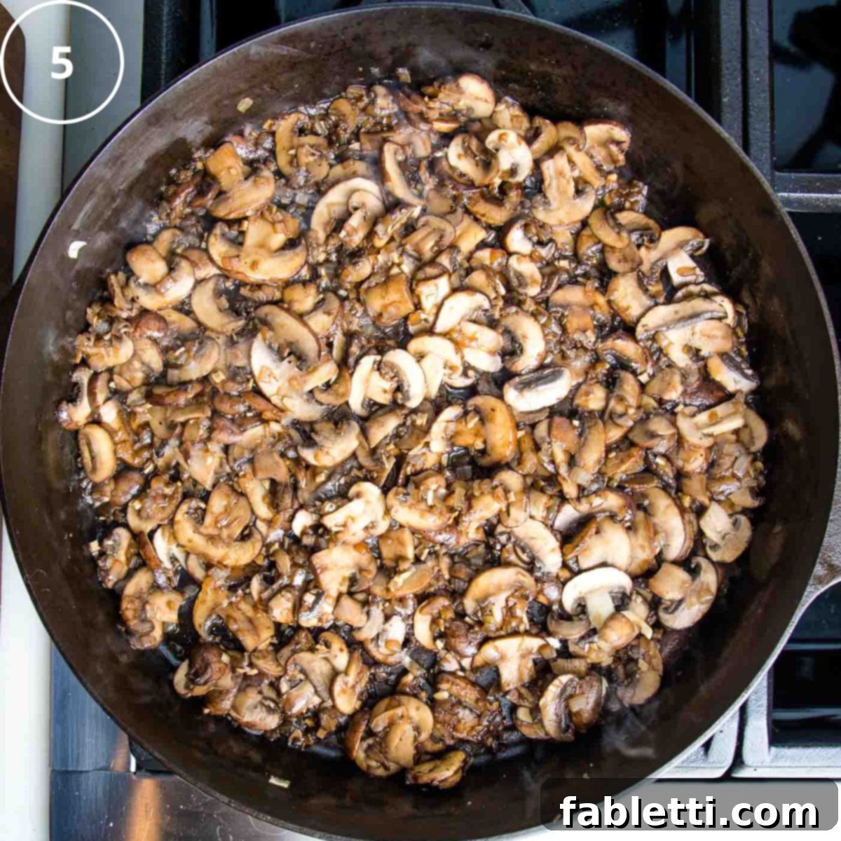 Hearty Vegan Mushroom Stroganoff 9 Balsamic vinegar being added to caramelized mushrooms and onions in a hot cast iron skillet, creating a sizzle and rich aroma.
