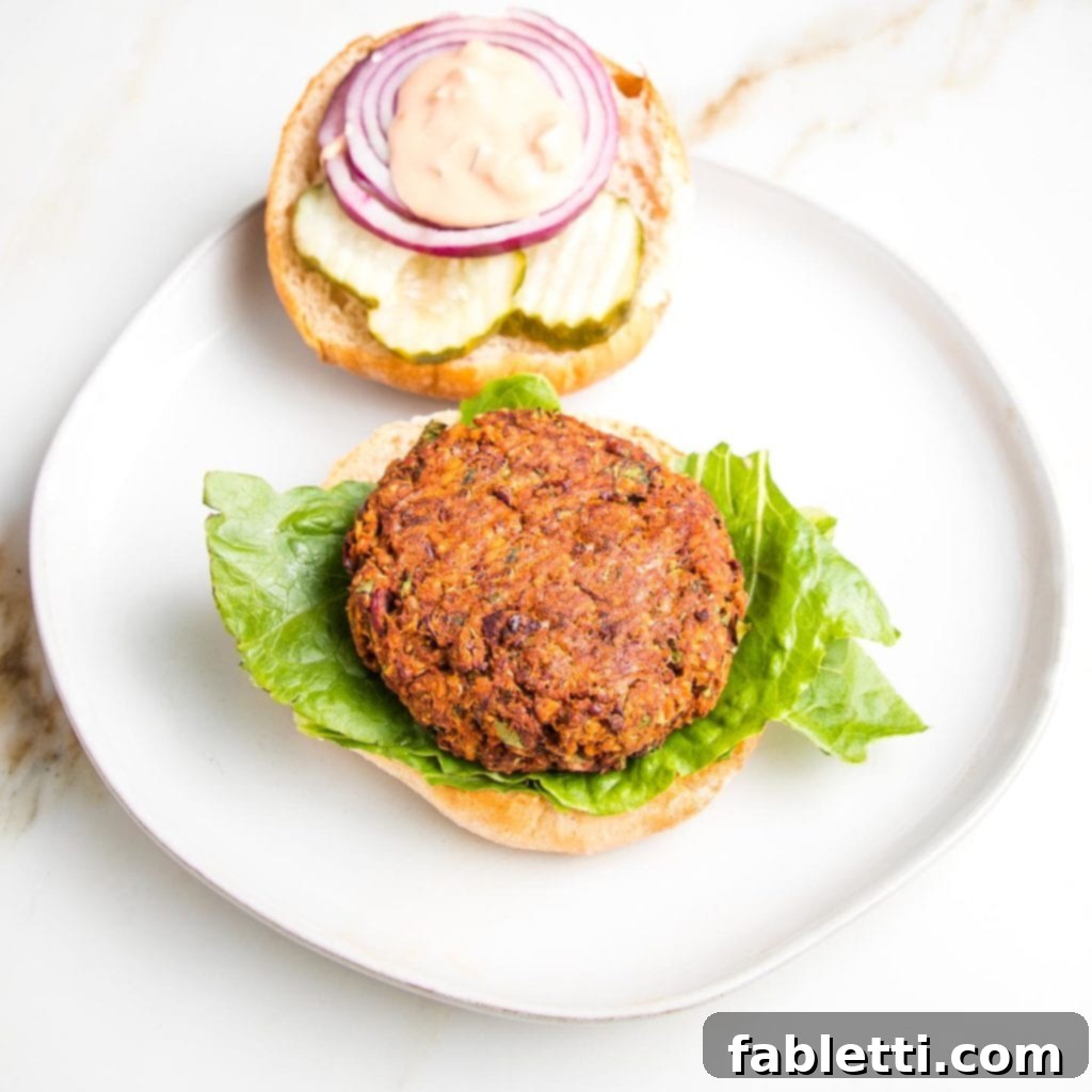 A beautifully plated quinoa veggie burger, perfectly golden and garnished with fresh herbs, ready for a delightful meal.