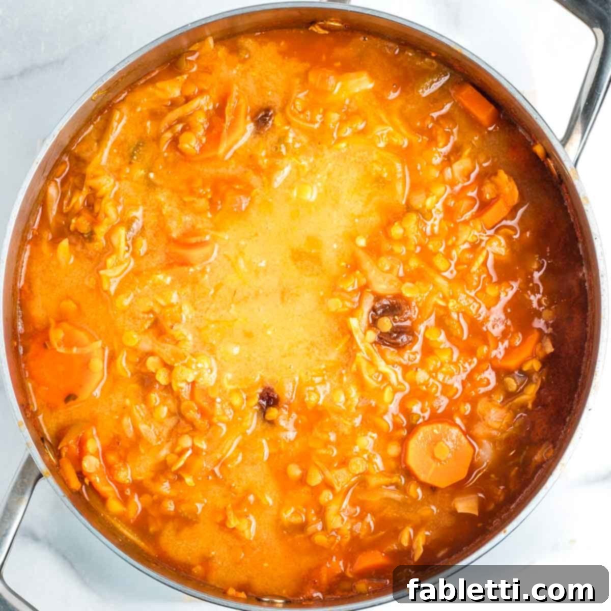 Tangy Vegan Cabbage Soup 12 Pouring the miso slurry into the simmering cabbage soup.