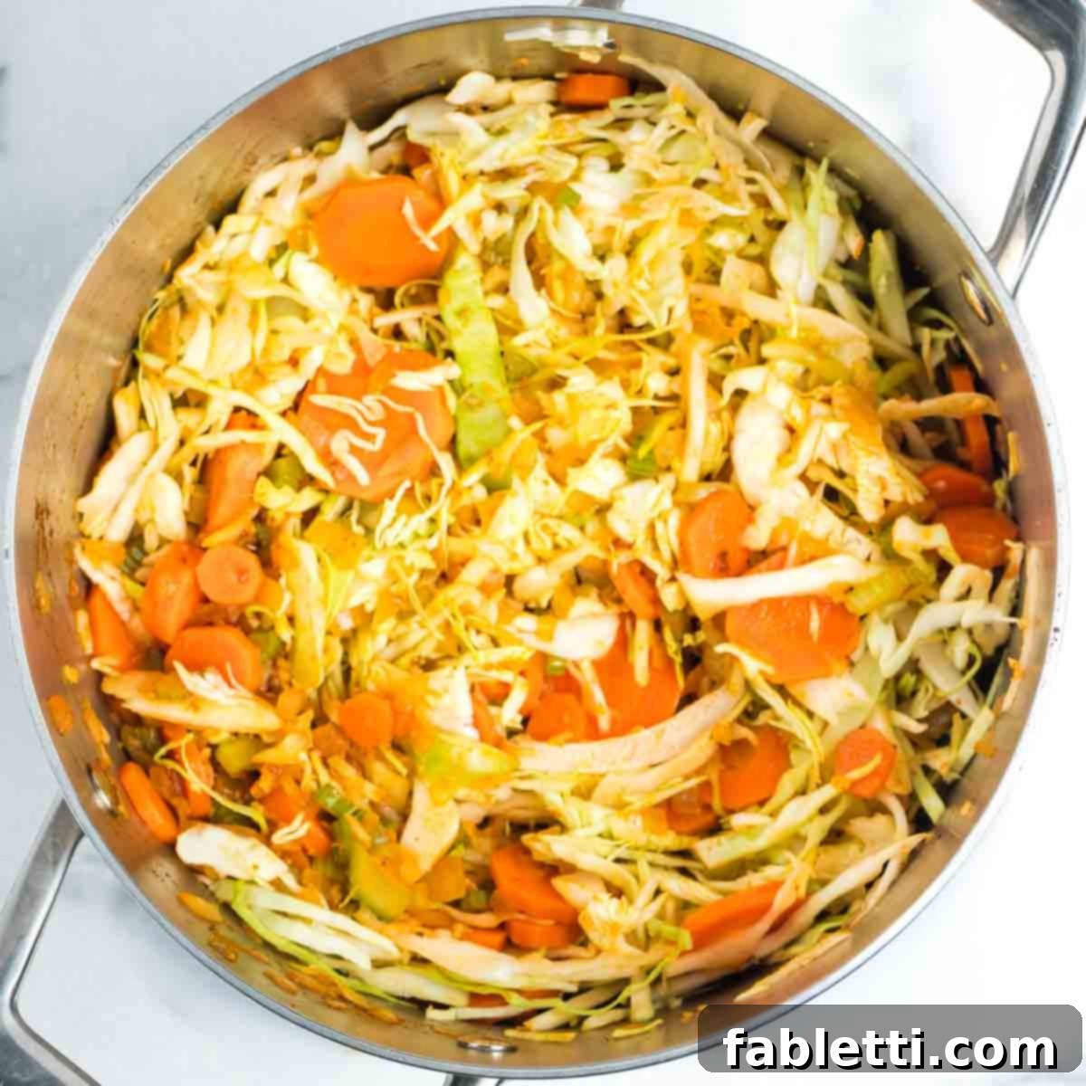 Tangy Vegan Cabbage Soup 7 Shredded cabbage being mixed into the sautéed vegetables.